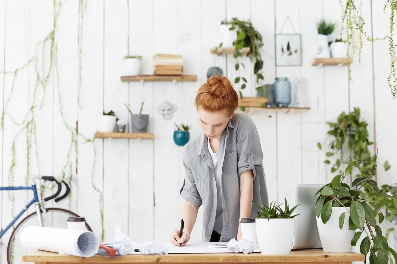 Konzentrierte junge kaukasische rothaarige Ingenieurin mit Dutt
